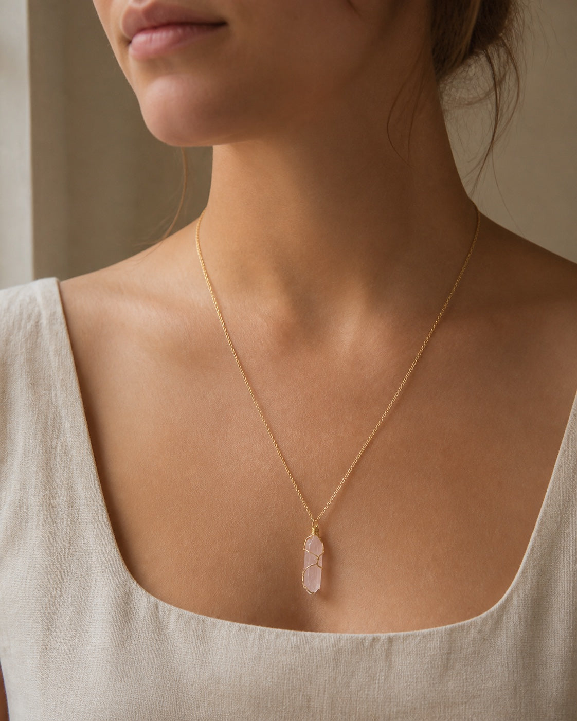 Rose amulet worn with a neutral linen neckline